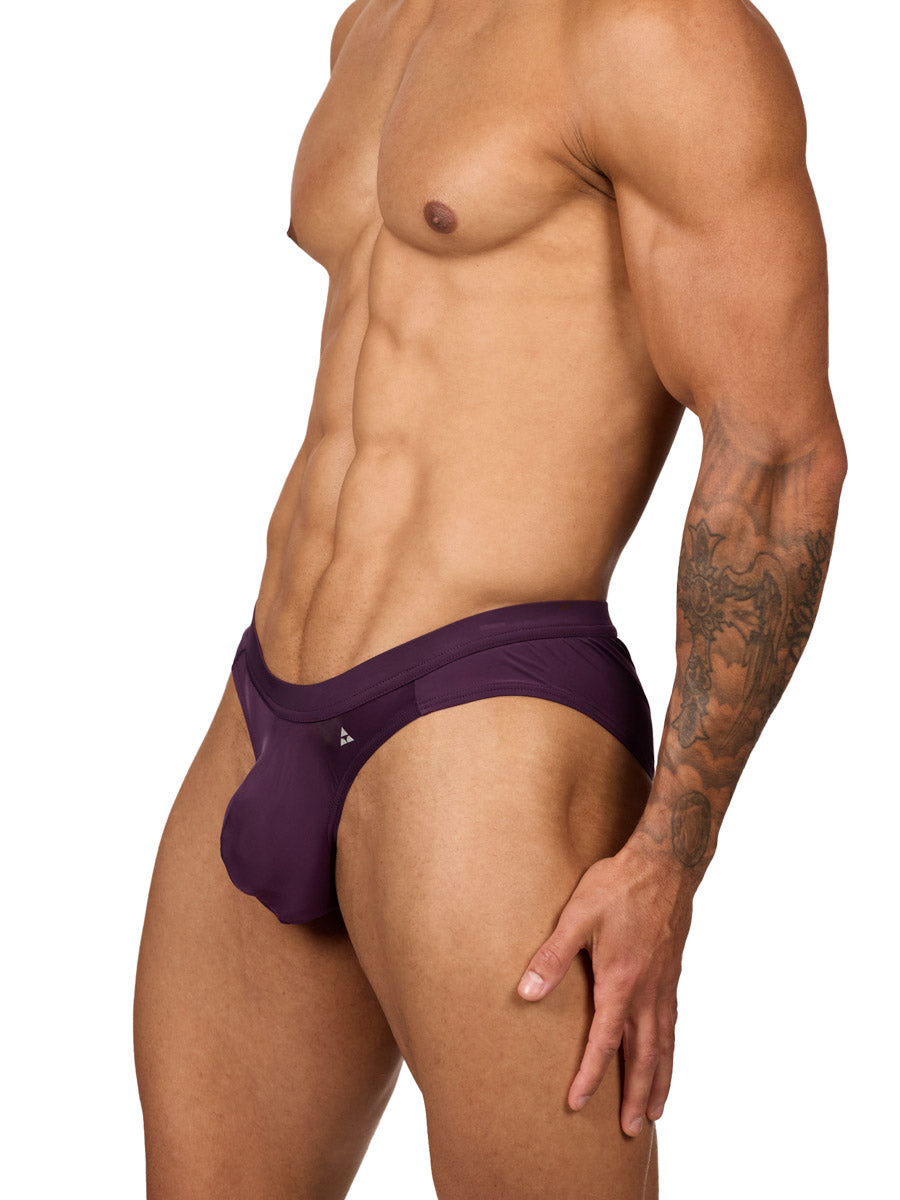 Side view of a muscular male model wearing purple Body Aware briefs with matching waistband