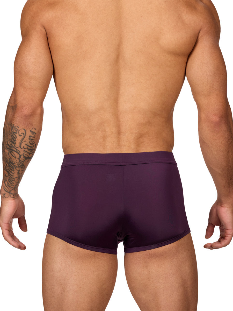 Rear view of a muscular male model wearing purple Body Aware boxer shorts