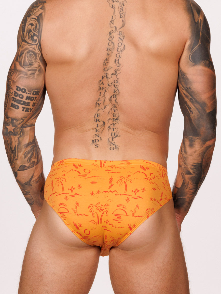 Back view of male model wearing an orange Body Aware brief with red tropical designs