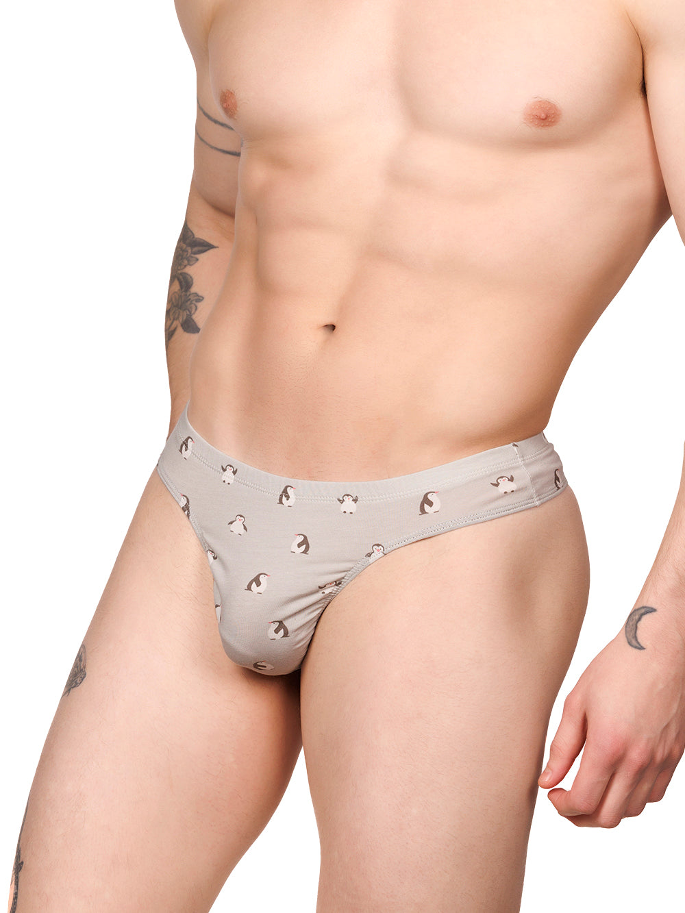 Side view of a male model wearing a grey Body Aware thong with a penguin print pattern