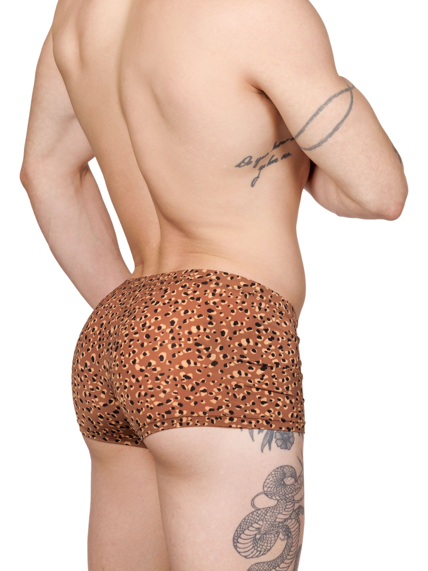 Side view of a male model wearing brown Body Aware boxer shorts with a leopard spot pattern