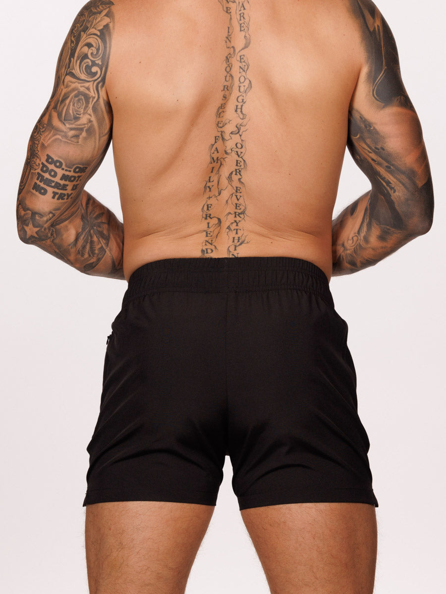 Back view of a male model wearing black Body Aware athletic shorts