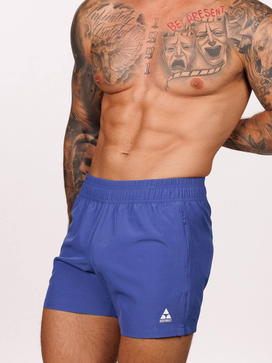 Front view of a male model wearing blue Body Aware athletic shorts