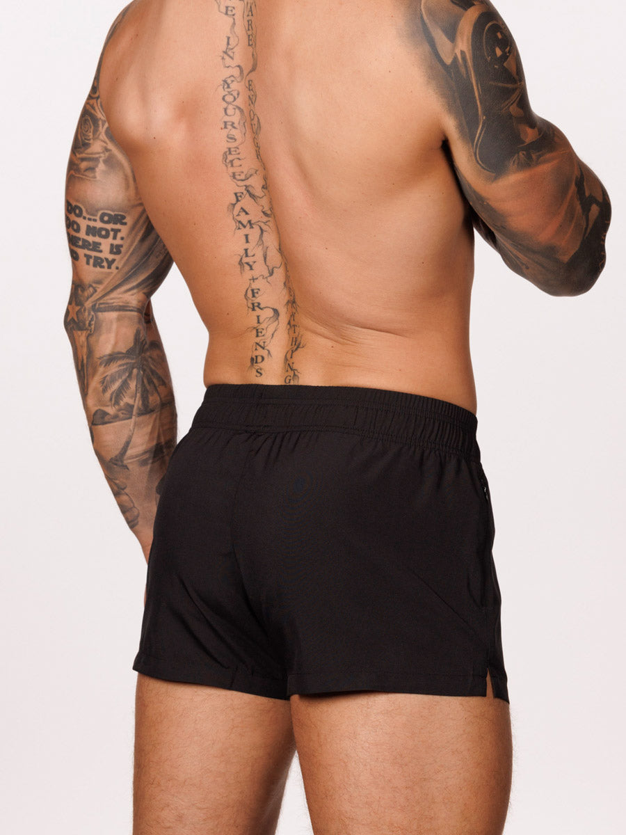 Side view of a male model wearing black Body Aware gym shorts with drawstring