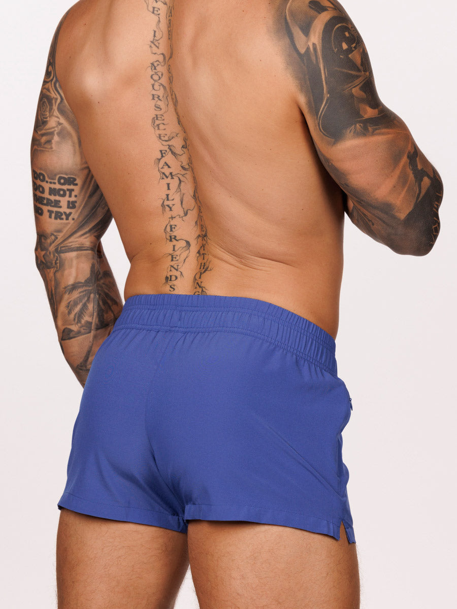 Back view of a male model wearing blue Body Aware square leg gym shorts 