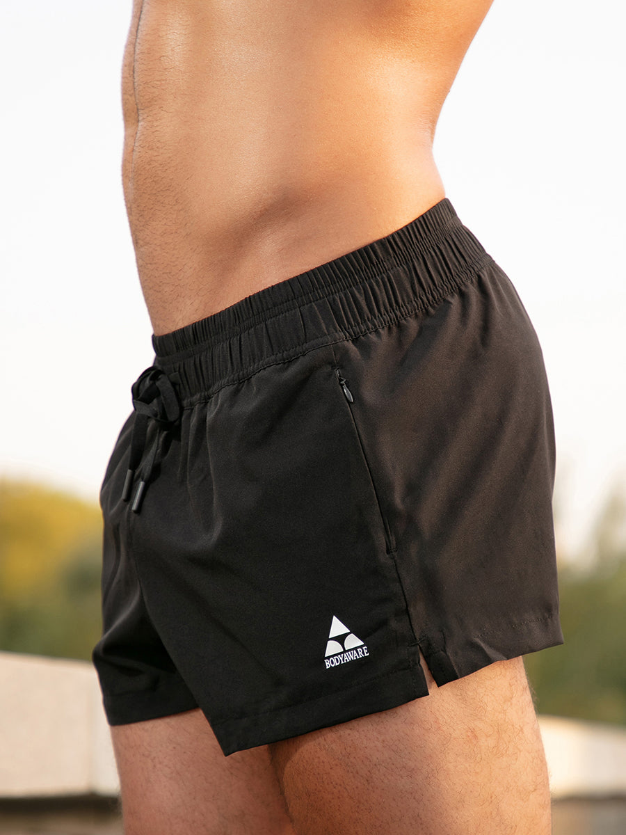 Side view of a man wearing black athletic shorts with a black drawstring and white Body Aware logo