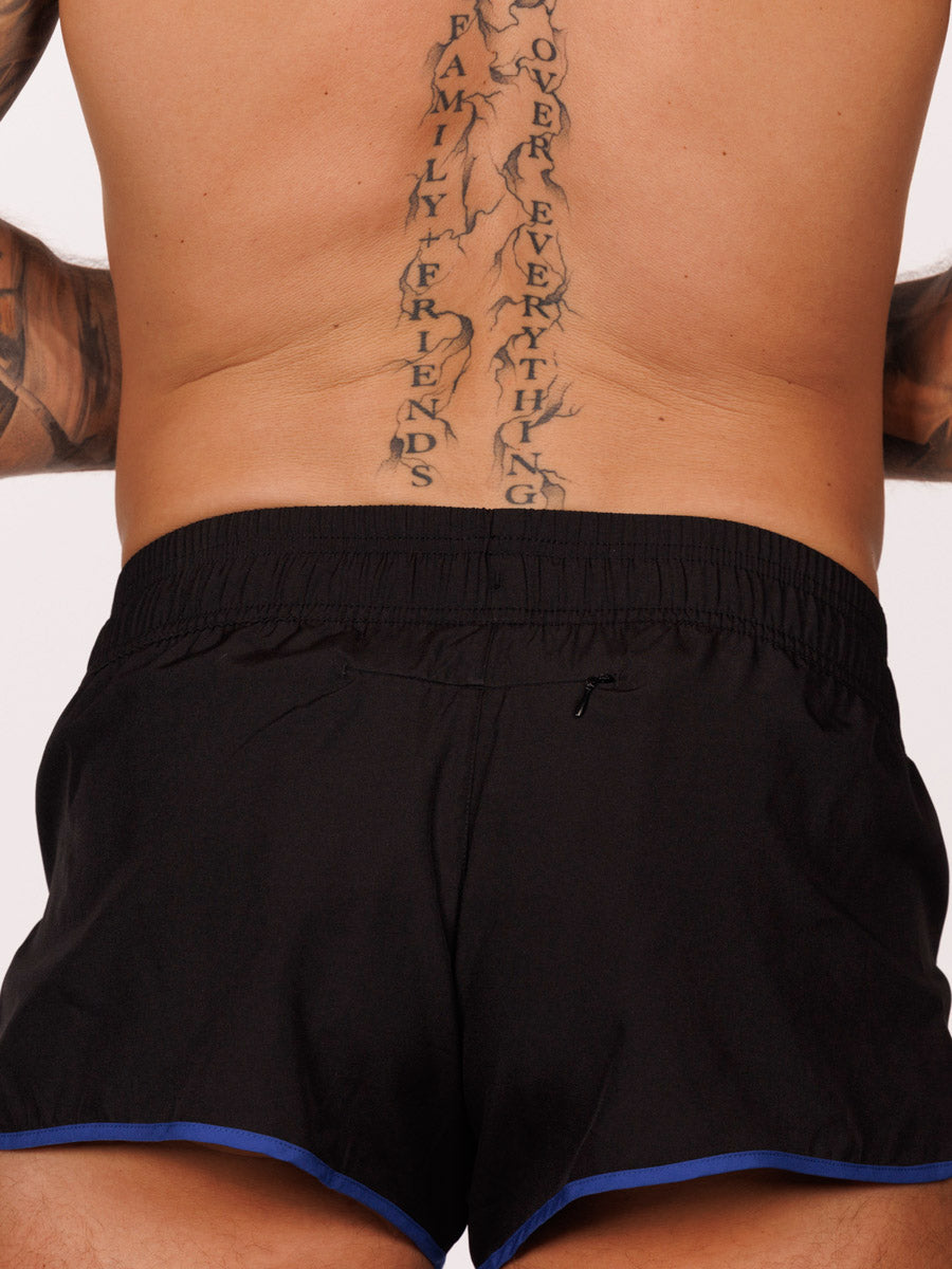 Closeup view of a male model wearing black Body Aware running shorts