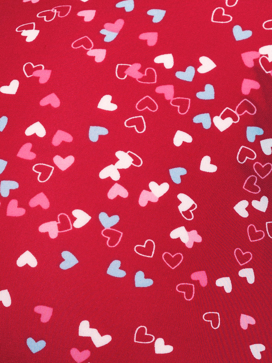 Closeup view of red fabric with a multicolor heart pattern