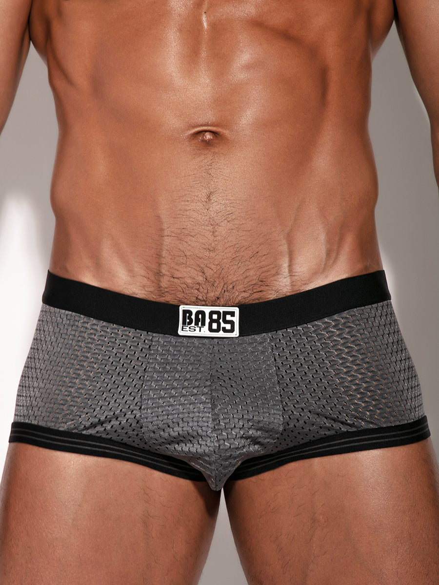 Closeup view of a man wearing grey boxer briefs with a black waistband and Body Aware branding.