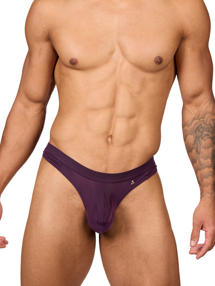 Front view of a muscular male model wearing a purple Body Aware thong with matching waistband