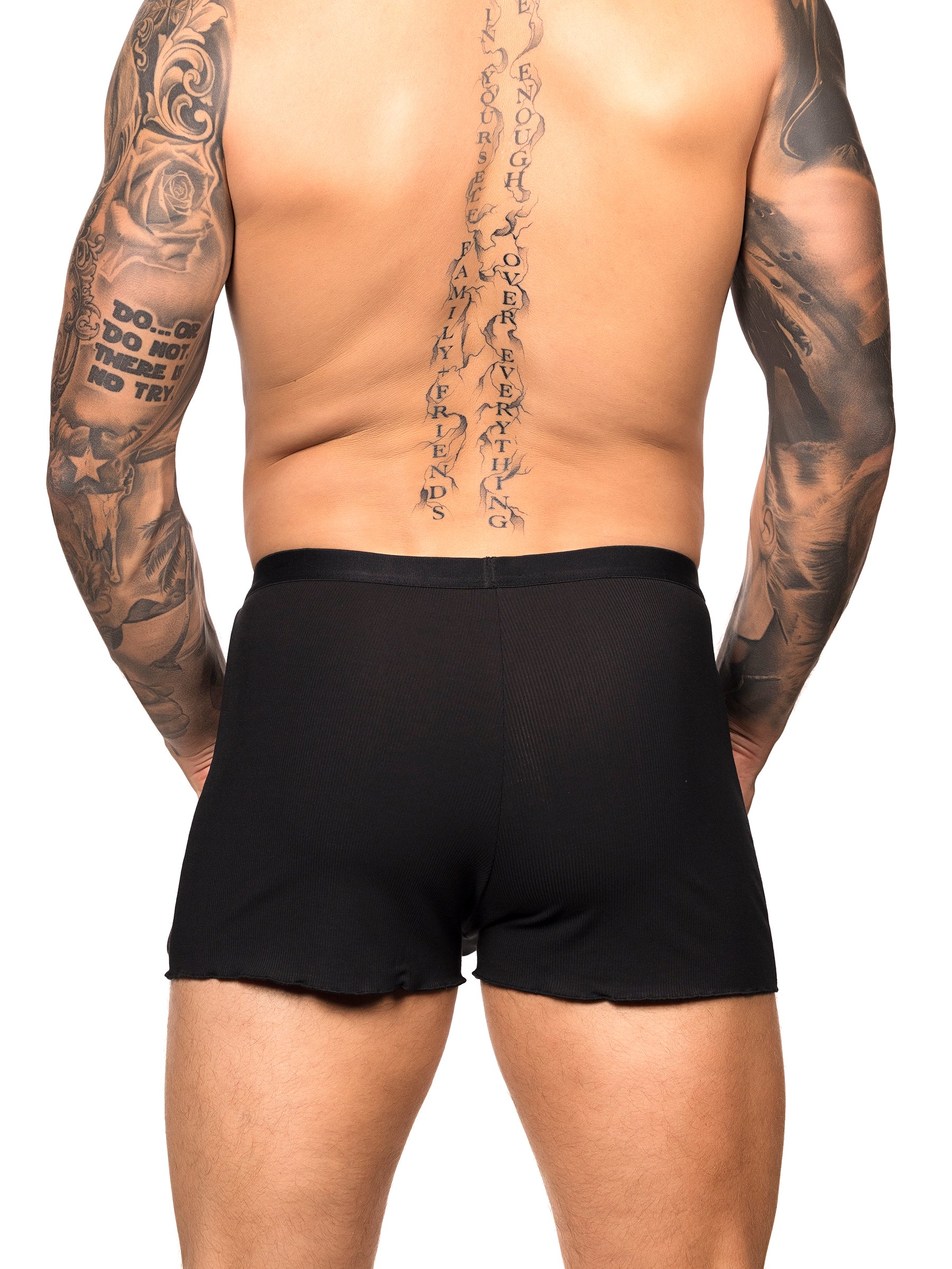 Back view of a male model wearing black Body Aware shorts