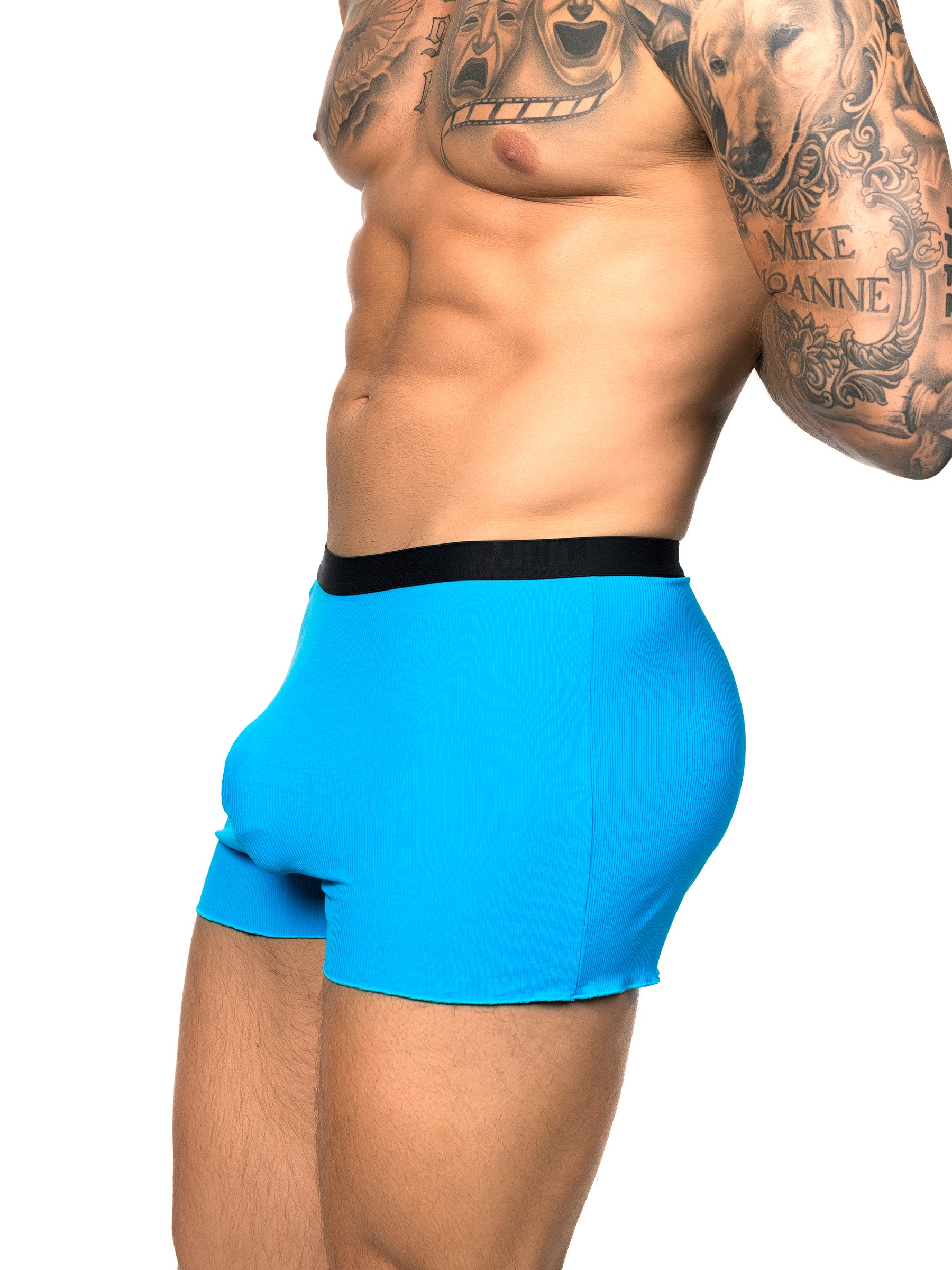 Side view of a male model wearing turquoise Body Aware shorts with black waistband