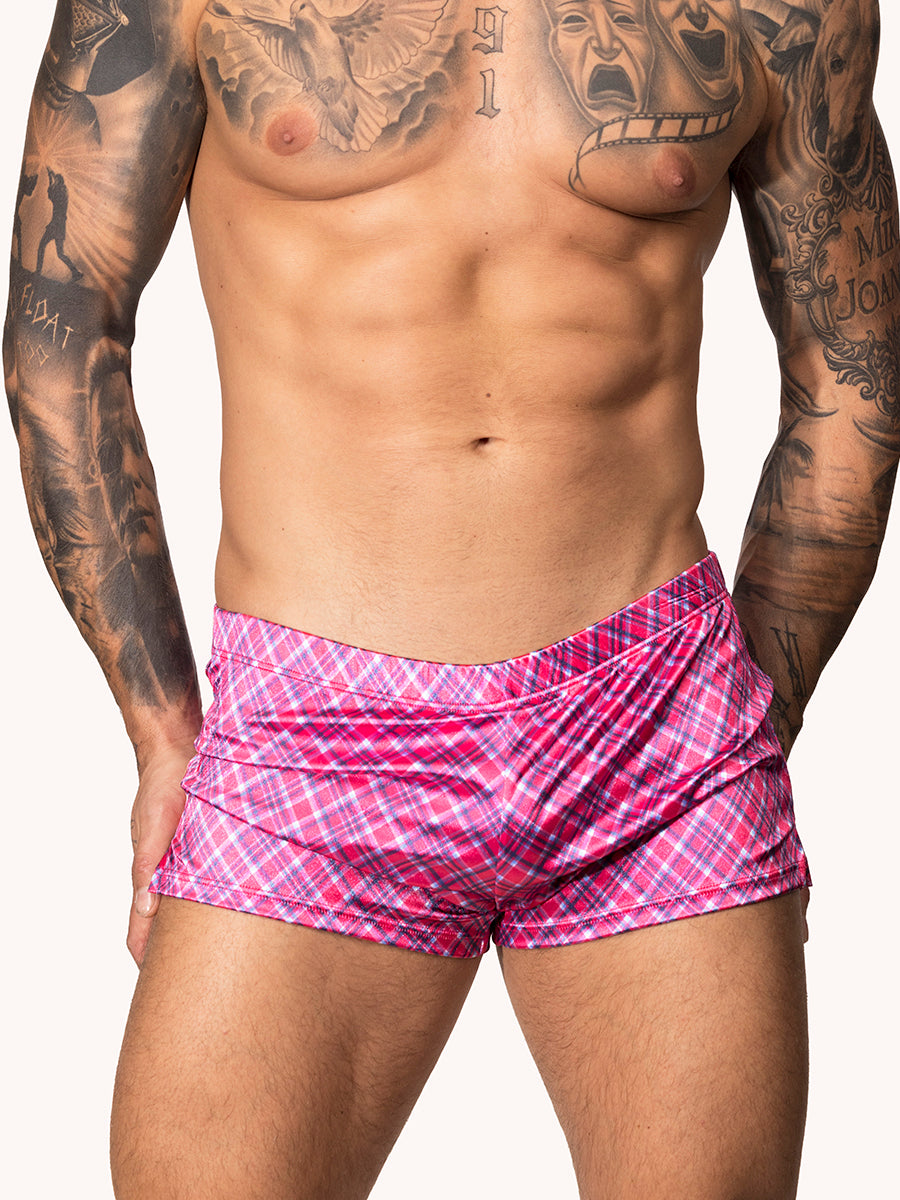 Front view of a male model wearing pink plaid Body Aware shorts 