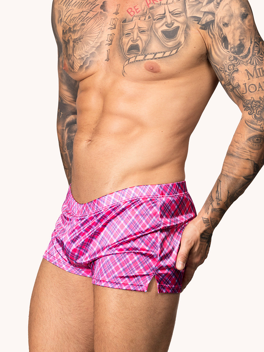 Side view of a male model wearing pink plaid Body Aware shorts 