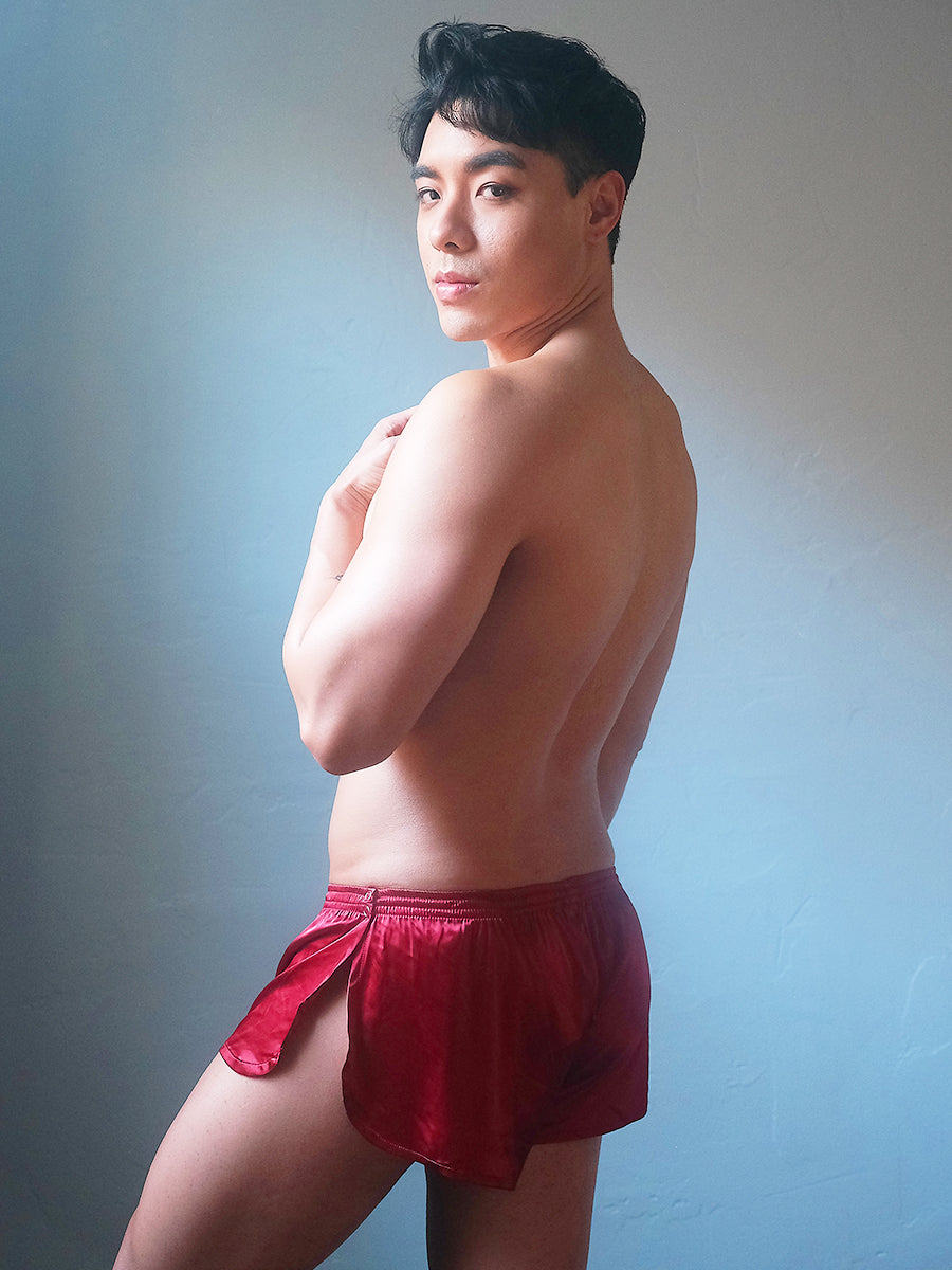 Side view of a male model wearing Body Aware red men's tear away shorts