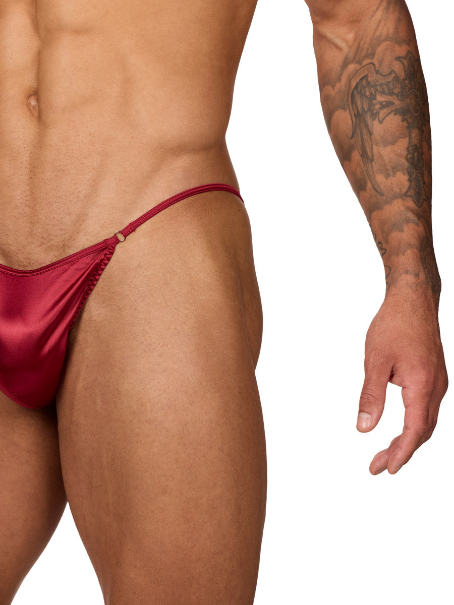 Closeup view of a male model wearing a Body Aware red men's bikini brief, showing waistband details. 